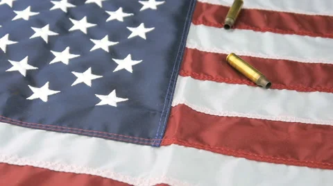 Panning Shot of Bullet Shells Falling on American Flag in Slow Motion Stock Footage 61296924