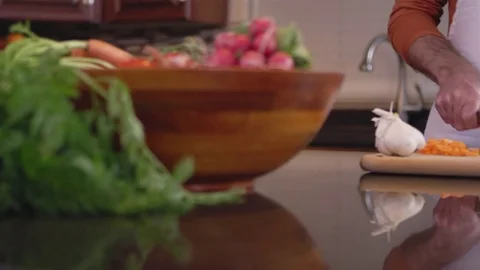 Panning shot of a chef chopping some carrots on a cutting board Stock Footage 83010025