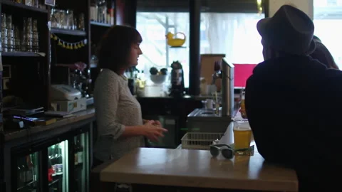 Panning Shot Of Customer Talking To Bartender At Beer Bar Counter Stock Footage 344889621
