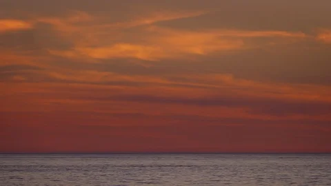 Panning shot of a dramatic, orange sky over the ocean Vídeo Stock 118617714