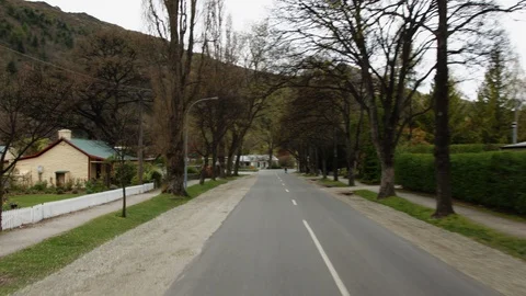 Panning shot driving down road in Arrowtown, New Zealand Stock Footage 89866753