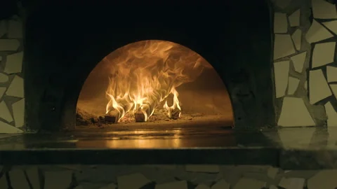 Panning shot of fire burning in a Classic stone pizza oven. Stock Footage 169469245