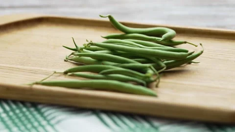 Panning shot of freshly harvested string beans on a striped kitchen towel Stock Footage 343555526