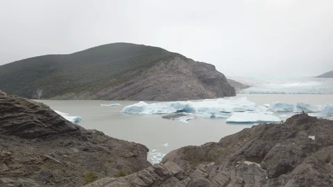 Panning shot of ice in bay surrounded by rocks and mountains, Patagonia, Chile Stock Footage 137967117