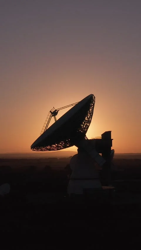 Panning shot of a large satellite dish broadcasting messages with sunset Stock Footage 283566918