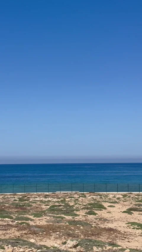 Panning shot from left to right of a Mediterranean rocky beach and calm sea Stock Footage 336333967