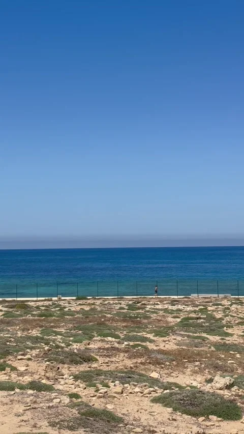 Panning shot from left to right of a rocky coastline hill near ancient ruins Stock Footage 336333956