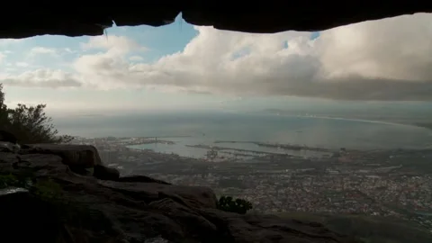 Panning shot of man walking through edge of cave opening Video stock 310385608