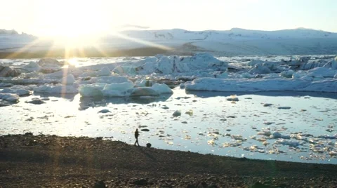 Panning Shot of Model Walking Across Glacial Lagoon in Iceland Stock-Footage 56451942