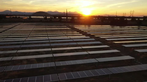 Panning shot of mountain sunset with solar panels in foreground Stock Footage 160888692