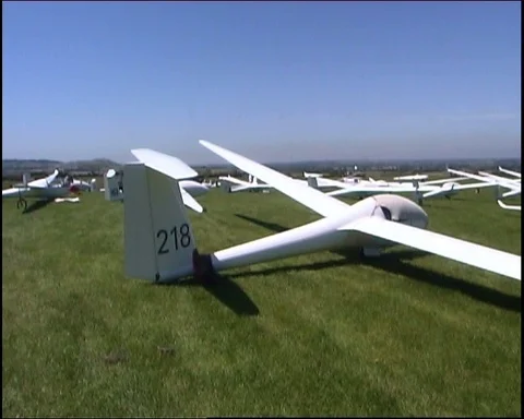 Panning shot of multiple gliders parked on airfield Video stock 95608631