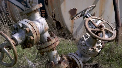 Panning shot at old and rusty valves and barrel at field Stock-Footage 88258642