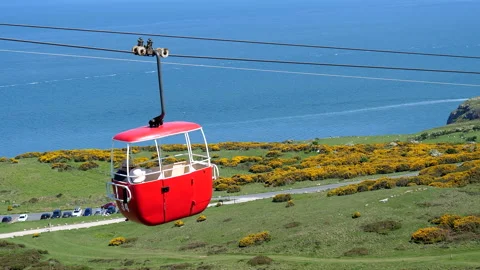 Panning shot of open air cable car cabin above scenic hill Видео 161990616