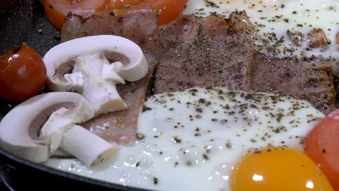 Panning shot over bacon with eggs in a pan Stock-Footage 88259958