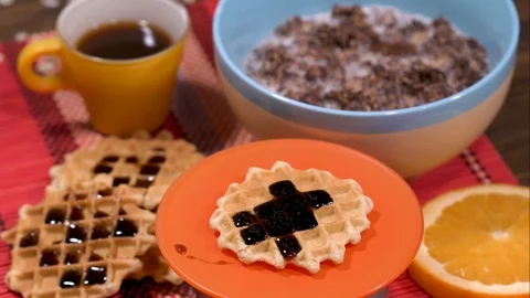 Panning shot over breakfast set with waffles, coffee, muesli and orange Vídeos de archivo 88255855