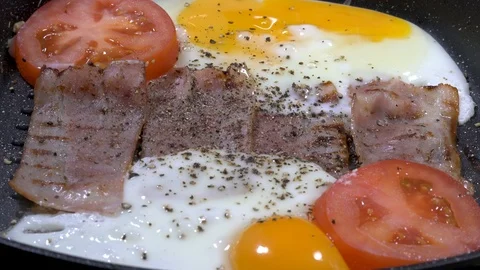 Panning shot over gril pan with grilled bacon slices and eggs Stock-Footage 88260247