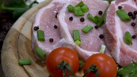 Panning shot over raw steaks on rotating wooden plate Stock-Footage 88257306