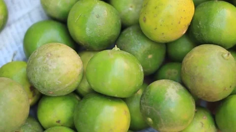 Panning shot of a pile of fresh small limes being sold at a farmers market stall Stock Footage 101877012