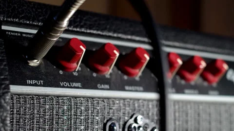 Panning shot of plugging into a guitar amplifier Stock Footage