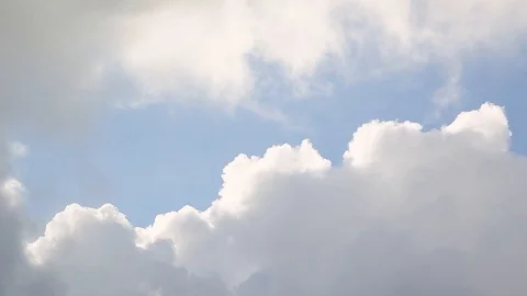 A panning shot of puffy white clouds against a blue sky. Видео 99161892