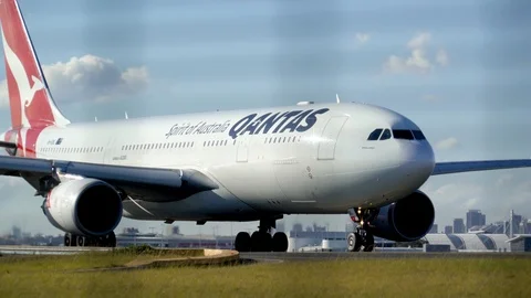 Panning Shot of QANTAS Jet as it moves Across Sydney Airport Tarmac Stock Footage 97624110