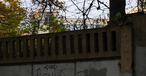Panning shot of a razor wire topped metal fence being shaken as if by a prisoner Stock Footage 56566745