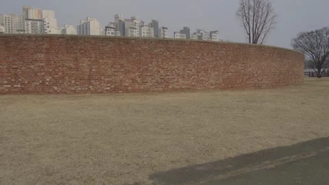 Panning shot of a red brick construction outside Stock Footage 299893601