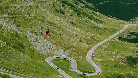 Panning shot of red cable car above Transfagarasan road, Romania. Video stock 342271716