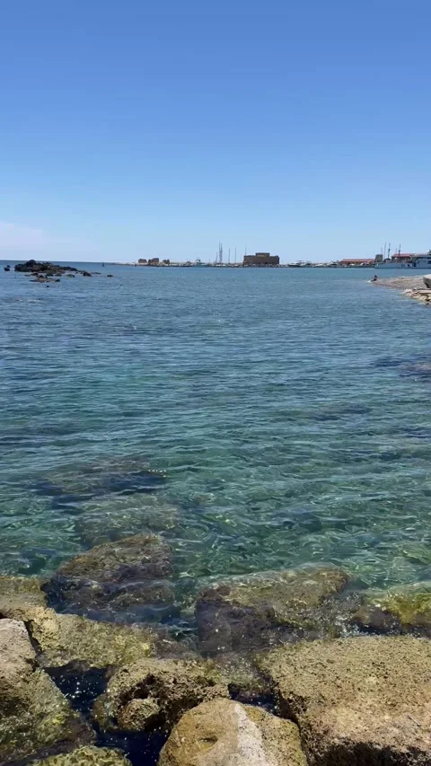 Panning shot from right to left across a scenic rocky coastal beach and blue sea Stock Footage 336278679