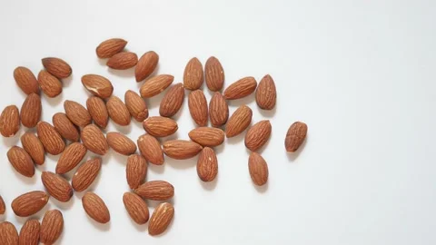 Panning shot of roasted almonds on white background Stock Footage 104234785