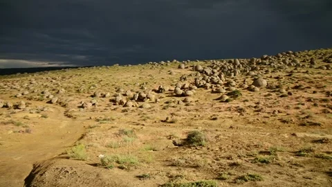 Panning shot of rolling desert hills with round boulders Stock Footage 344966394