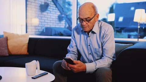 Panning shot of senior man looking at the screen on his mobile phone Stock Footage 99013271