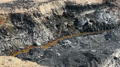 Panning shot showing the leftover of the coal mining process at the open mine Stock Footage 313352707