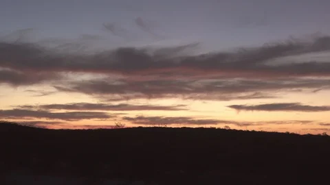 Panning shot of silhouette landscape against orange sky during sunset, beauty of Video stock 128850737