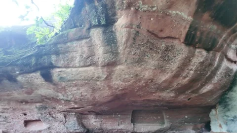 Panning shot of a stone mountain pathway leading under a  red sandstone cliff Stock Footage 338365481
