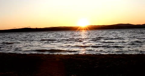Panning shot of the sun setting over the beautiful lake Stock Footage 211066563