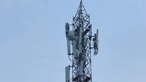 Panning Shot of Telecommunications Cell Tower with Multiple Cellular Antennas Stock Footage 346821316