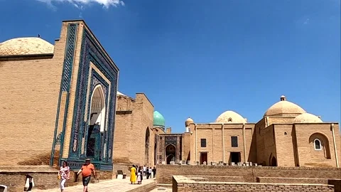 Panning shot of tourists exploring the Shah-i-Zinda courtyard in Samarkand Stock Footage 336807438