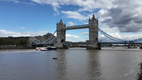 Panning shot of Tower Bridge over River Thames with boats passing beneath Stock Footage 346677564