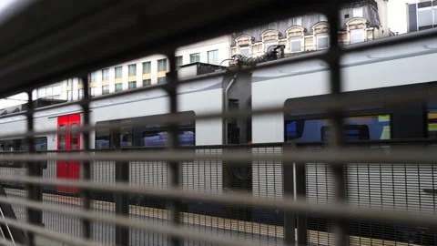Panning shot of train leaving behind fence in station with second class carriage 動画素材 219775111