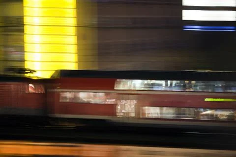 Panning Shot of a Train Speeding Through Berlin at Night Stock Photos
