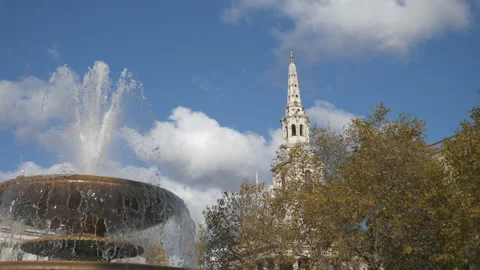 A panning shot of trees surrounding an old fountain. Autumn in a city. Stock Footage 119674976
