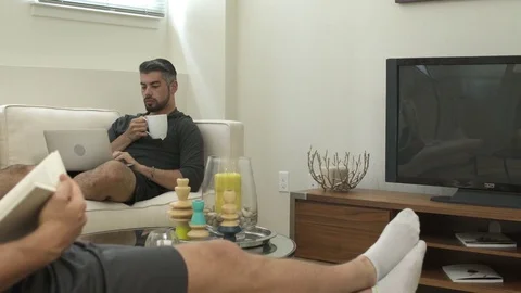 Panning shot of two men relaxing at home 動画素材 76235629