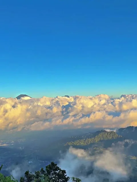 Panning Shot of Volcanic Mountain Slopes and Village Above Clouds Stock Footage 339775962