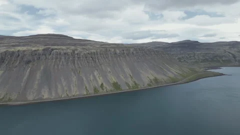 A panning shot of a volcanic mountains surrounding a lake in Iceland. Stock Footage 282801181