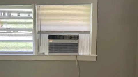Panning Shot of Window Air Conditioner Installed in Residential Window Stock Footage 339979719