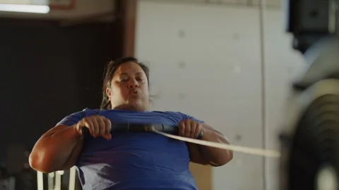 Panning shot of woman using rowing machine in gymnasium / Lehi, Utah, United Stock Footage 94429959