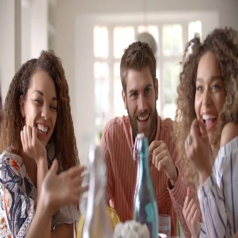 Panning shot of young adult friends talking at dining table Stock Footage