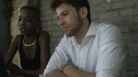 Panning shot of young creative professionals discussing over laptop in office Stock Footage 114855884