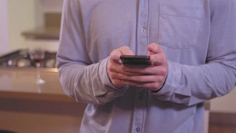 Panning shot of a young man using his cellphone in his living room Stock Footage 83006686
